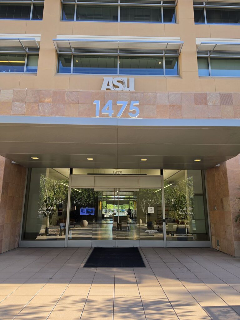 Glass entrance and awning of the ASU SkySong building at 1475, in morning sun.